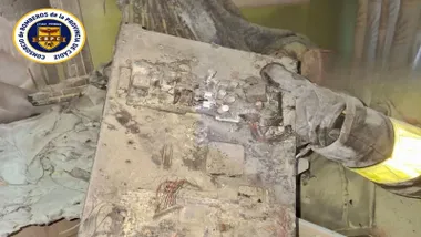 Placa del televisor destrozada sostenida por un bombero.