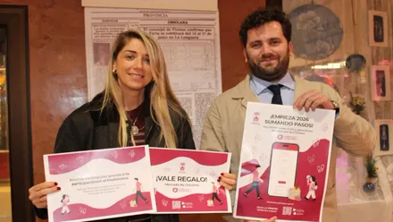 Sierra y Butrón sostiene el cartel en sus manos.