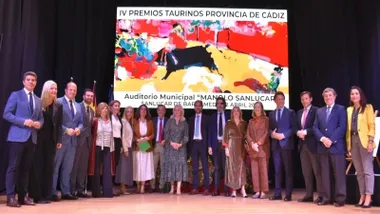 Galardonados en los IV Premios Taurinos posando delante de una pantalla con un toro.