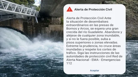 Aviso recibido en el móvil de los vecinos, a su lado pantano de Arcos desaguando.