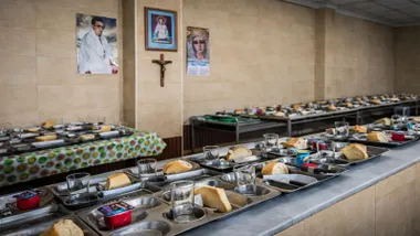 Mesas largas con platos y raciones de comidas en un comedor social en San Fernando.