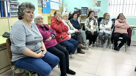 Grupo de mujeres en el curso, están sentadas observando las indicaciones.