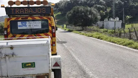 Maquina amarilla y roja con cartel que pone "trabajos" y una carretera secundaria.