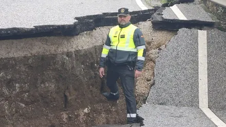Un guardia civil muestra el tamaño de un hundimienro de una carretera en Cádiz. Foto: Subdelegación del Gobierno.