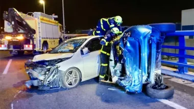 Dos vehiculos chocados en Puerto Real, no de ellos volcado lateralmente en el que intervienen los bomberos.