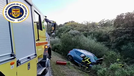 Bomberos trabajando para recuperar el automóvil siniestrado.