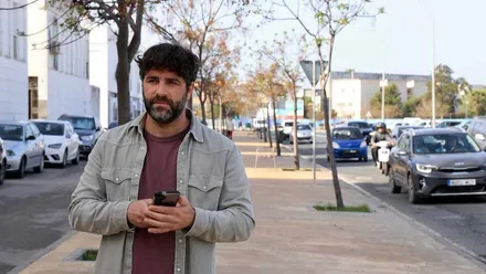 Roberto Palmero con cazadora vaquera y árboles tras él.