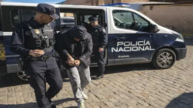 Detenido esposado junto a un policía nacional.