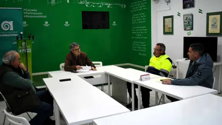 Sala verde y blanco con Romero hablando con otras personas en AxSí.