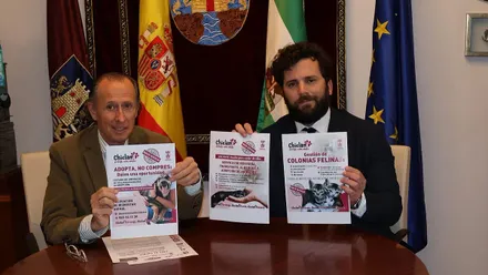 El alcalde José María Román y Guillermo Sierra muestra el documento referente al bienestar animal.