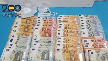 Muchos billetes, sobre todo de 50 euros, también de 5 euros; hay droga en una mesa de la Policía Nacional.