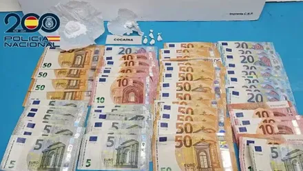 Muchos billetes, sobre todo de 50 euros, también de 5 euros; hay droga en una mesa de la Policía Nacional.