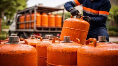 Hombre cogiendo, entre muchas bombonas de butano, una de ellas.