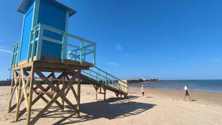 Nueva torre de vigilancia en la la playa de La Caleta al estilo californiano con el Castilllo de San Sebastián al fondo.