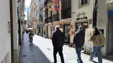 Dos personas pasan por delante de una tienda de productos gaditanos en el centro de Cádiz.