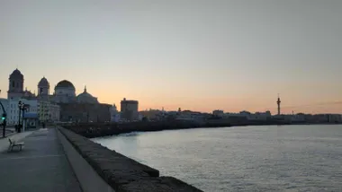 Amanecer en Cádiz desde el Campo del Sur con la Catedral y el paseo marítimo al fondo