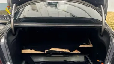 Fondo de un coche caleteado, se muestra el maletero.