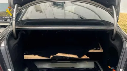 Fondo de un coche caleteado, se muestra el maletero.