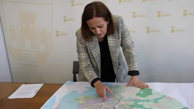 Mapa en una mesa con Ana González señalando con el dedo.
