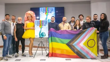 Posado con la bandera del Orgullo y el cartel en las dependencias municipales.
