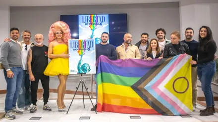 Posado con la bandera del Orgullo y el cartel en las dependencias municipales.