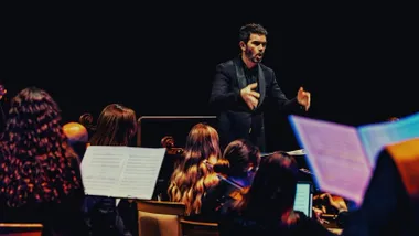 Director de orquesta marcando el "tempo" de la música.