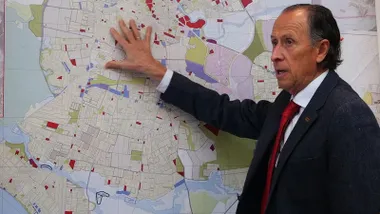 José María Román, apoya la mano en un mapa explicando los daños que ha ocasionado los temporales de lluvia.