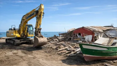 Excavadora derribando las chozas.