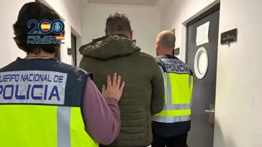 Policias nacionales llevan al detenido a una celda.