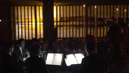 Clarinetistas tocando en una iglesia a la luz de las velas.