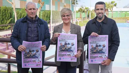 Tres personas sostienen el cartel de enfermedades raras en Rota.