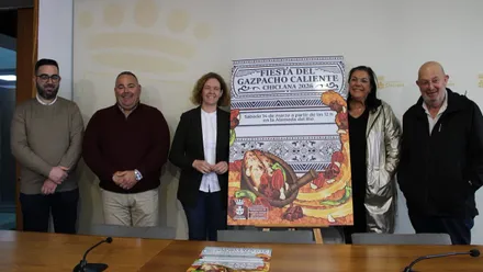 La delegada y los organizadores junto al cartel de la Fiesta del Gazpacho Caliente.