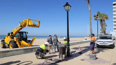 Operarios instalando una farola en el Paseo Marítimo de Rota.