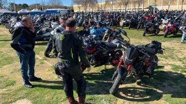 Muchas motos y personas de pie sobre el césped en Rota.