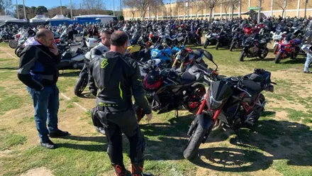 Muchas motos y personas de pie sobre el césped en Rota.