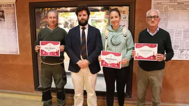 Cuatro personas, entre ellas el delegado Guillermo Sierra, sostienen el premio en sus manos, es un diploma de color rojo y blanco.