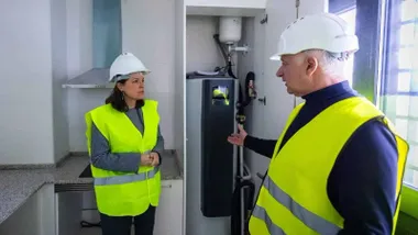 Patricia Cavada, con chalequillo reflectante, atiende las explicaciones que le dan en una obra en un piso.