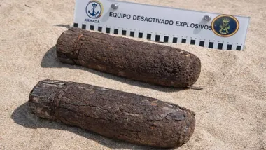 Piezas de artillería antiguas, muy oxidadas, en la playa de Camposoto junto con un cartel de la Armada.