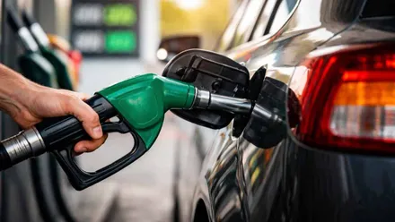 Mano con una manguera de gasolina repostando.