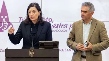 Momento de la intervención de Patricia Cavada, de elegante chaqueta negra, delante de una pantalla blanca con letras moradas que dice: “Tu respeto, parte de nuestra pasión”.