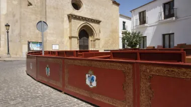 Vallas de color burdeos con el escucho de Sanlúcar como palcos de su Semana Santa.