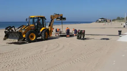 Excavadora y operarios en los trabajo de Rota.