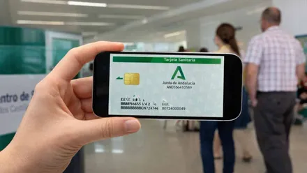 Persona sosteniendo un móvil con la tarjeta digital sanitaria del SAS.
