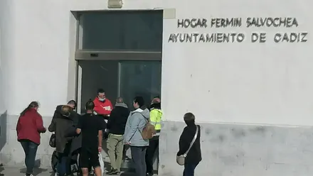 Personas usuarias del Centro de Día fermñin Salvochea en el acceso del mismo.