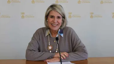 Rico en una mesa y sonriente mientras presenta el curso.