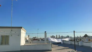 Azotea de Cádiz con ropa tendida y cielo azulísimo, despejado y la Iglesia de San Antonio al fondo