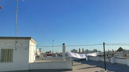 Azotea de Cádiz con ropa tendida y cielo azulísimo, despejado y la Iglesia de San Antonio al fondo