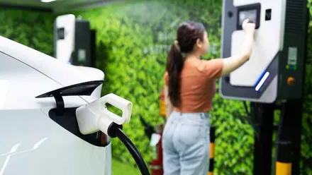 Mujer programando un cargador para su coche eléctrico.