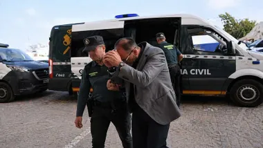 Guardia Civil acompañando a un acusado esposado desde el furgón.