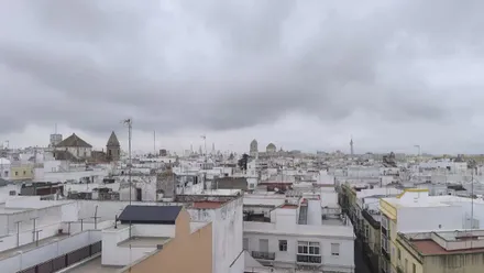 Imagen de Cádiz con la Catedral de Cadiz y la iglesia de Santa Cruz bajo un cielo nublado que amenaza lluvia